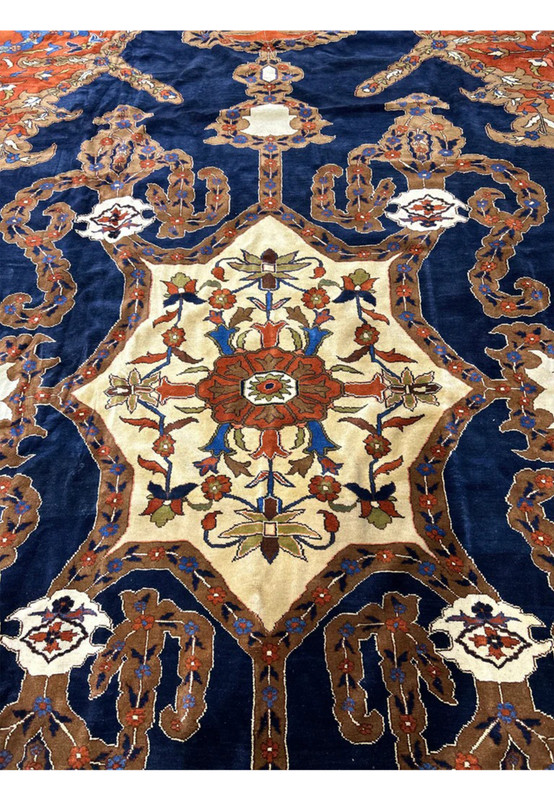 Ivory eight point star medallion with rust rosette and camel surround on navy field