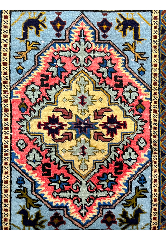 Layered medallion close-up: navy eight-pointed star, butter yellow core, sage and coral serrated petals on a collectible sample