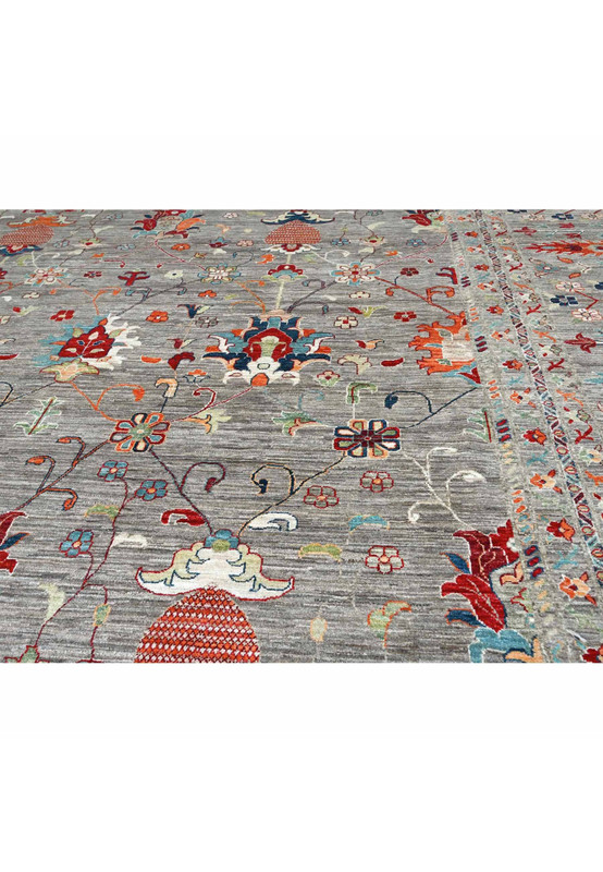 Tribal and geometric border motifs in red, teal, and ivory framing the grey oversize Sultani rug