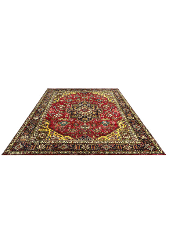 Vintage Tabriz laid flat showing the full red field, central medallion, and richly patterned indigo border