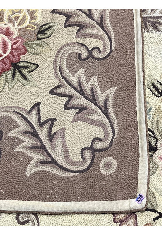 Backside of the hand-hooked rug showing the looped wool pulled through the cotton foundation