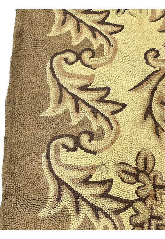 Close-up of the hooked wool loop pile showing acanthus scrollwork and the beaded texture of the border