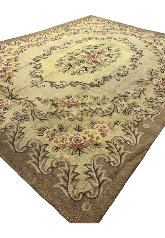 Angled view of the 8' x 11'4" hooked rug showing the cream Aubusson field and soft floral border