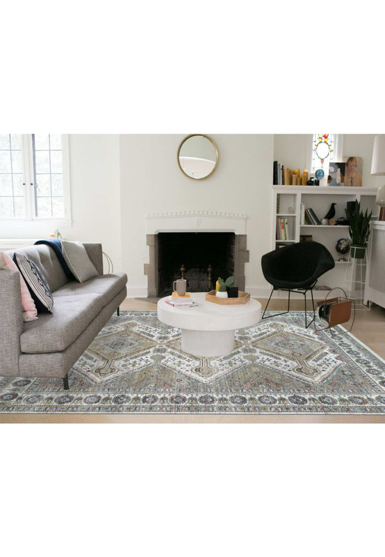 14x18 oriental Shiraz rug styled in a bright living room with a grey sofa and fireplace