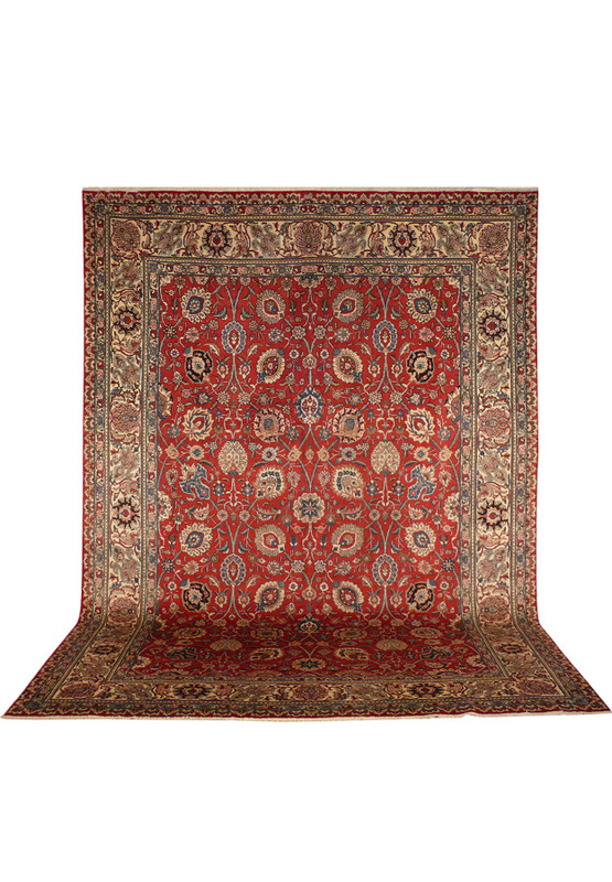 Vintage Persian Tabriz allover rug hanging flat showing rusty red field and navy border