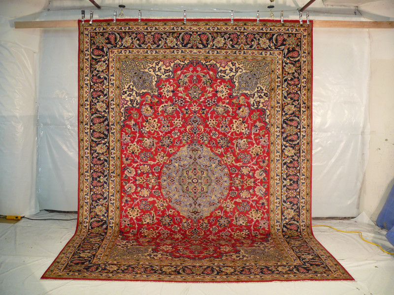 10 x 13 Isfahan Persian Rug hanging and unedited. Showing the complete rug with floral and botanical design.