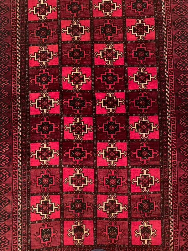 Close-up view of intricate patterns on the 3'5 x 5'6 Persian Baluch rug