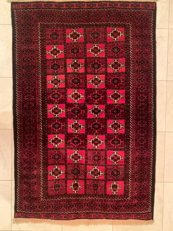The 3'5 x 5'6 Persian Baluch rug displayed in a traditional living room setting