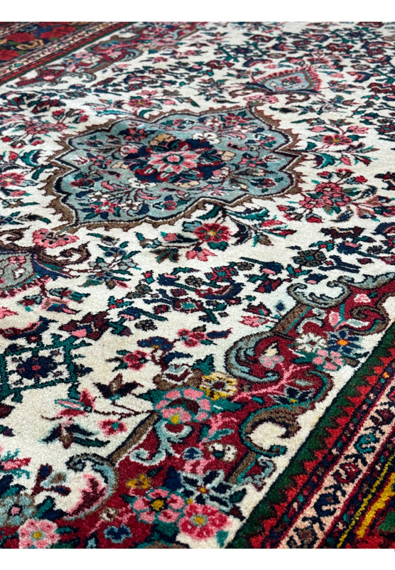 Close-up texture detail of a vintage Persian Bijar rug showcasing floral patterns and a diverse color palette
