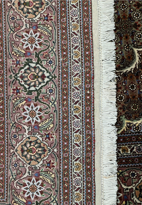 Close-up of the side border and fringe of a 5x7 Persian Tabriz Mahi rug, detailing the precision of the weave and the rich color variation of the wool and silk materials.