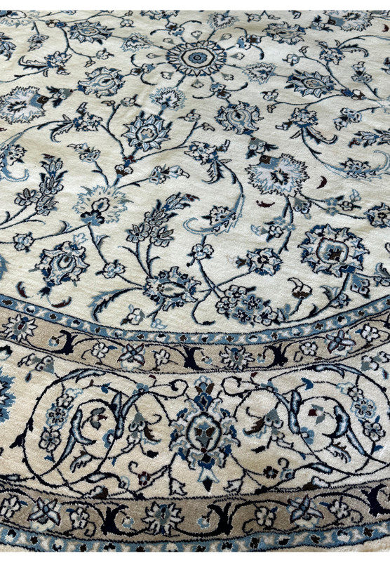 Ivory and blue Persian Nain round rug with traditional design.