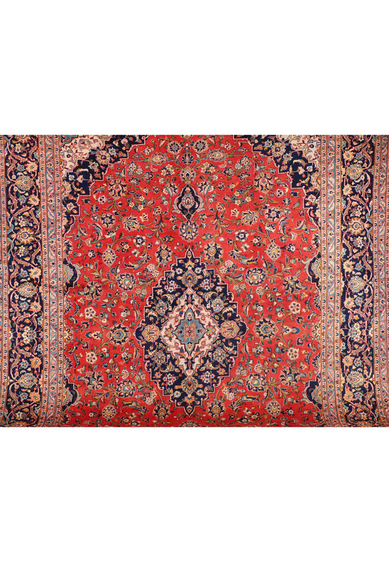 A close-up of the central part of the Persian Kashan rug, showcasing the detailed design and color variations within the central medallion and surrounding floral motifs.