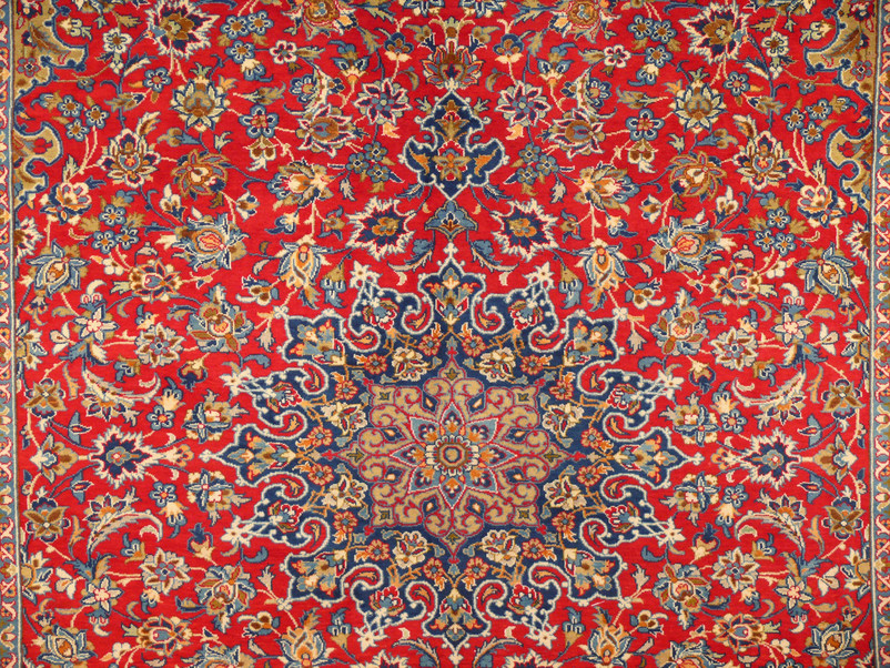 close up of majestic central medallion of a 10x13 Isfahan Persian rug with deep red tomato red background