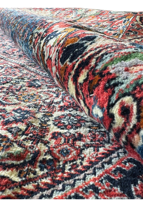 Rolled view of 9'10" x 13'1" Persian Bijar rug showing vibrant pattern diversity.