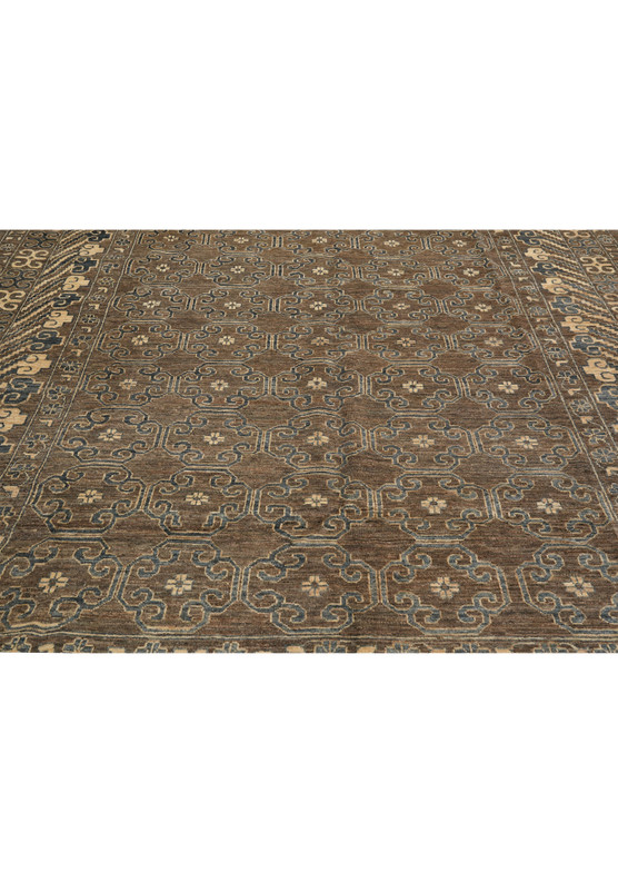 Zigler rug midfield view with repeating geometric floral lattice in grey, brown, and beige, handwoven wool design.