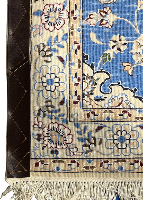 Corner of 2'8 x 17'2 Persian Nain 6LA Runner backside with leather reinforcement, ivory fringe, and floral border details.