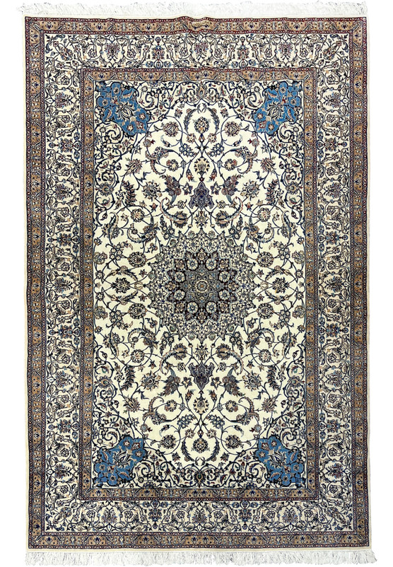 Full view of a signed 5'8" × 9' Persian Nain 4 LA Habibian rug showing ivory field, central blue floral medallion, and detailed beige and navy borders.