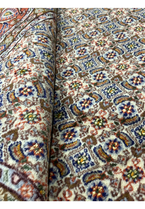 Rolled view of Persian Moud rug showing soft wool pile and elegant handwoven texture.
