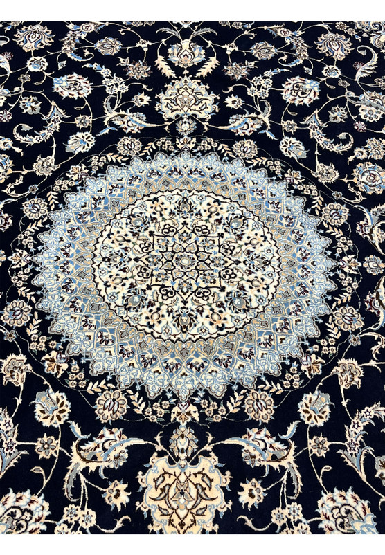 Detailed medallion of Persian Nain 6 LA Habibian rug featuring ivory and light blue silk, symmetrical geometry, and refined floral articulation