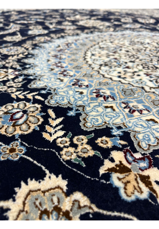 Color detail of a Persian Nain 6LA Habibian rug highlighting navy blue background with ivory, pale blue, taupe, and subtle burgundy floral accents