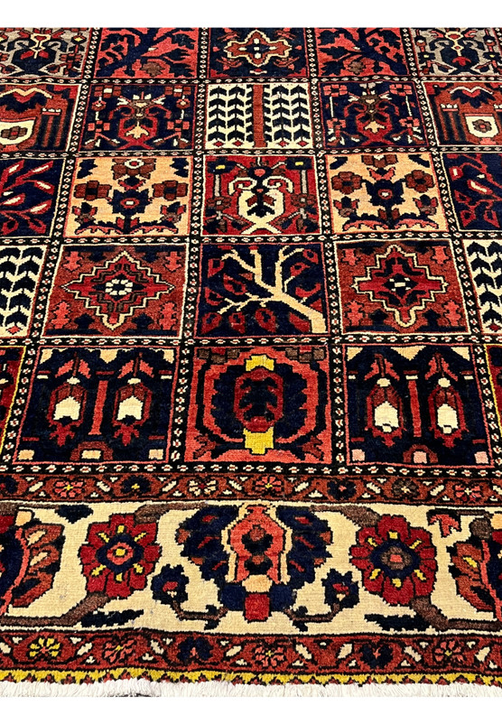 Lower border detail of a Persian Bakhtiar rug with ivory background and floral vine motifs