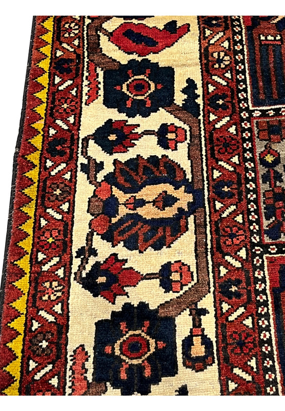 Zoomed view of the ivory floral border on a 7'4 x 10'1 Persian Bakhtiar garden rug showing vine motifs, rich reds, navy accents, and hand-knotted wool texture