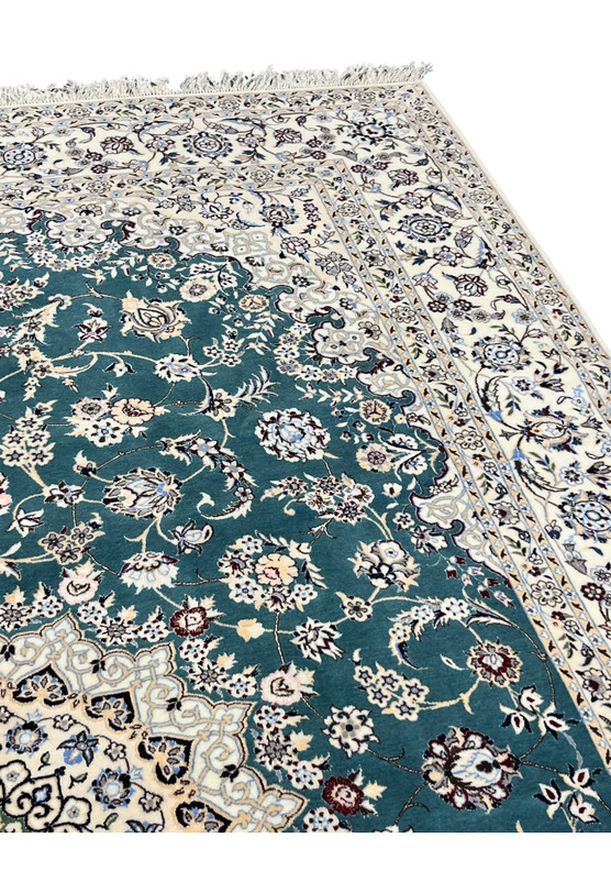 Upper border detail of 7x10 Persian Nain 6La Habibian rug with ivory floral vine on teal