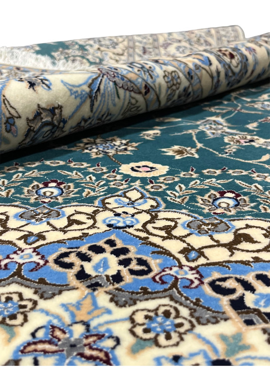 Rolled edge view showing dense pile and fine silk highlights across the emerald green and ivory surface