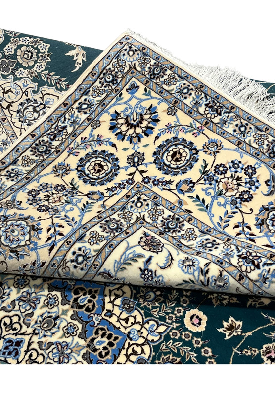 Folded edge revealing the flexibility and tight hand-knotted construction of this 600 KPSI Nain rug