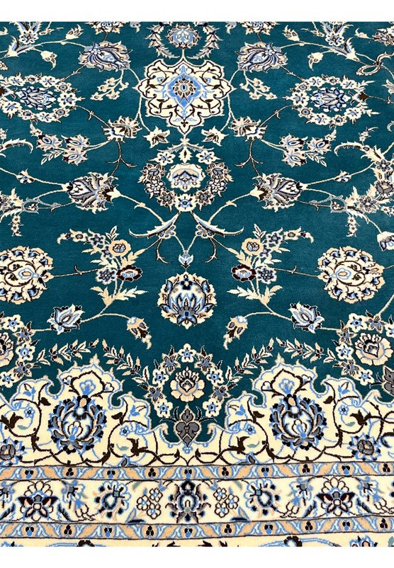 Emerald green field closeup showing silk-outlined palmettes and lotus blossoms in jewel tones