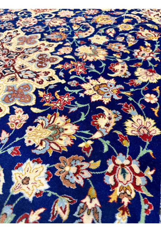 Macro view of the field motifs revealing the Shah Abbasi palmettes, lotus heads, and small jewel-toned floral clusters typical of fine Isfahan drawing