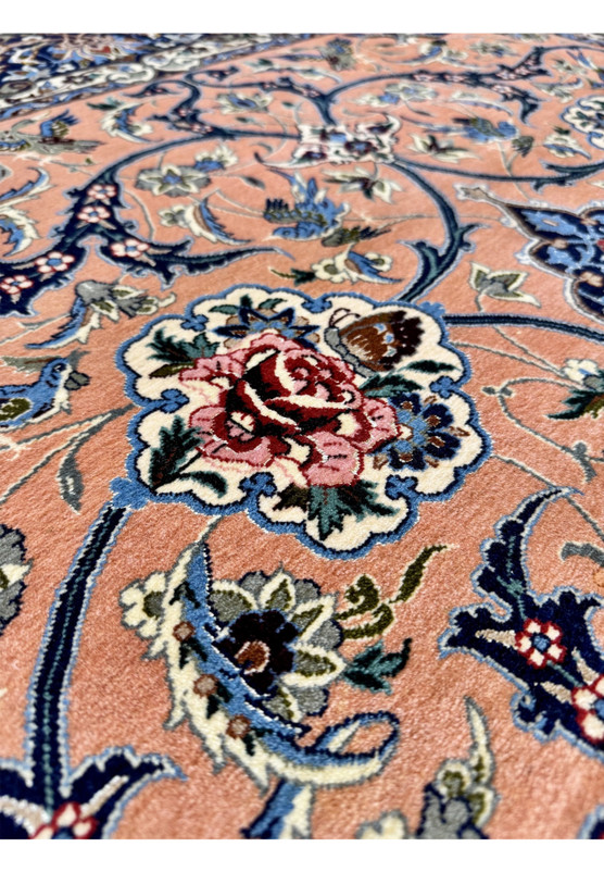 Macro detail of one rose cartouche showing the cabbage rose in deep ruby and pink with a small butterfly resting beside it on the salmon field