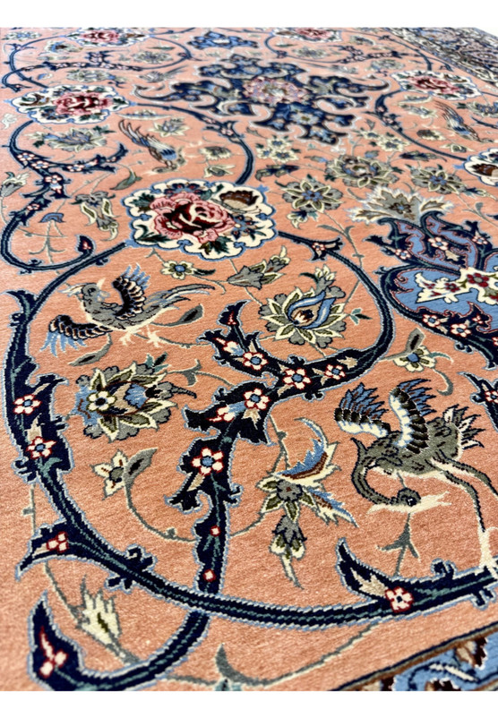 Mid-field view of the Davari Isfahan showing curling vines, paired peacocks, and rose roundels distributed symmetrically across the salmon ground