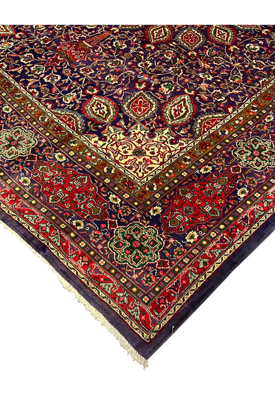 Edge view of Persian Tabriz wool rug showing aubergine outer guard band and red cartouche border