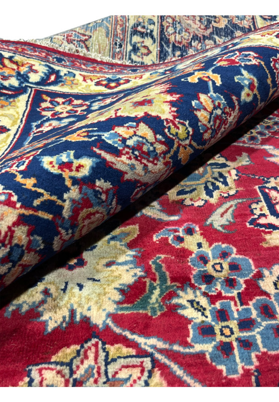 Rolled view of authentic Persian Isfahan rug showing flexible hand-knotted wool pile and saturated natural dyes