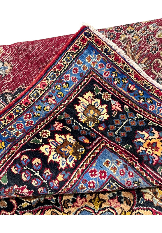 Folded edge of 8x11 Persian Kerman rug with backside detail showing fine 200 KPSI knotting and tight cotton foundation