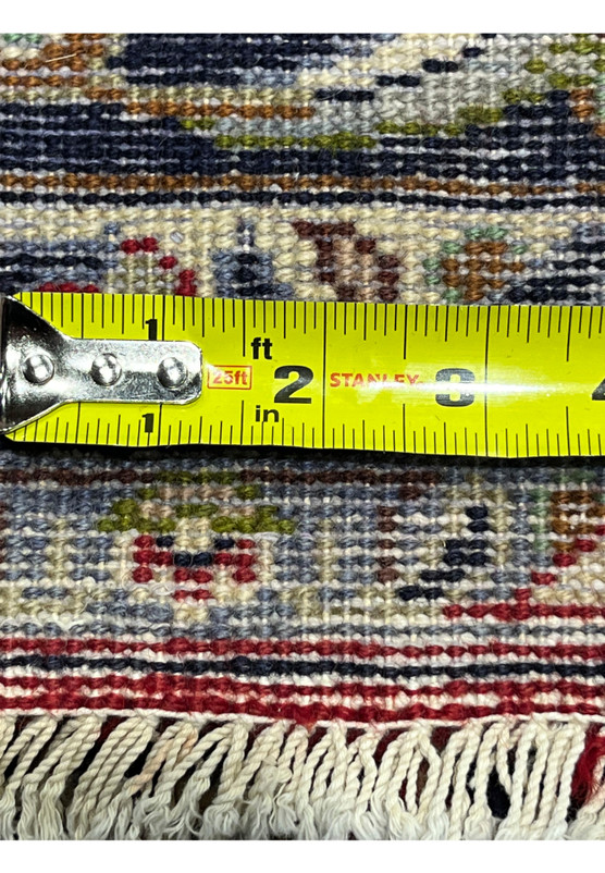 Backside of Persian Isfahan rug photographed with measuring tape against the weave for verification of fine 240 KPSI knot density