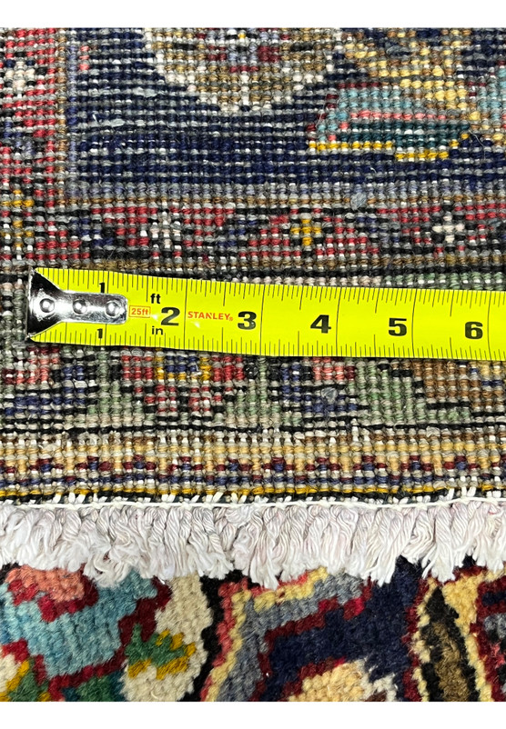 Backside of Persian Kerman rug photographed with measuring tape against the weave for verification of fine 200 KPSI knot density