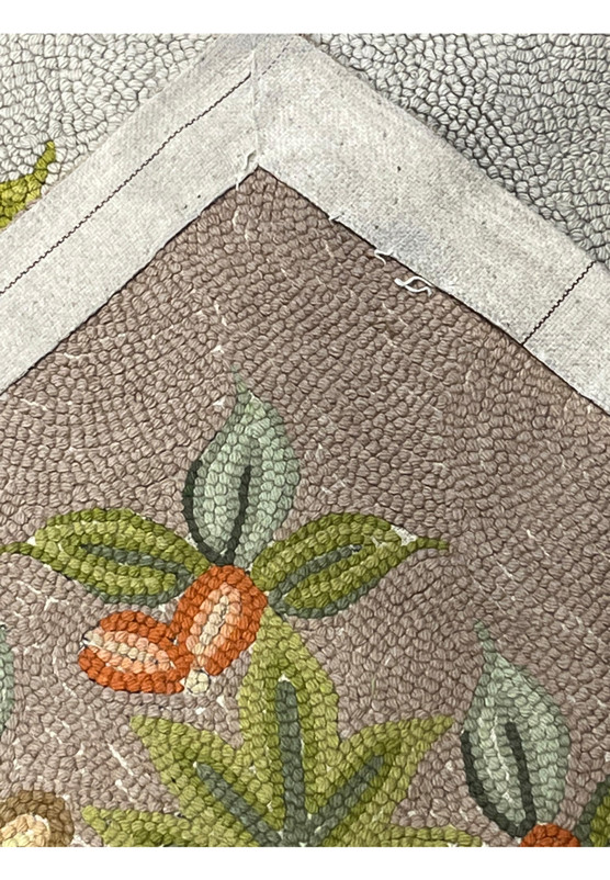 Reverse side of the hand hooked rug revealing its woven foundation and bound cloth edge