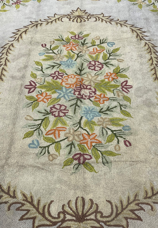 Central floral bouquet in orange purple and green wool, hand hooked for a formal living room