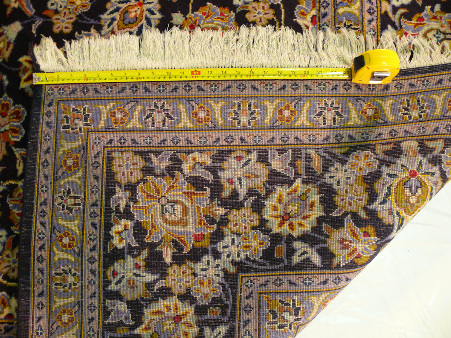 Revealing Quality - Persian Kashan Rug Density: Uncover the rug's craftsmanship with a view of the backside, featuring a ruler highlighting the dense knots that ensure the rug's durability and luxurious feel underfoot.