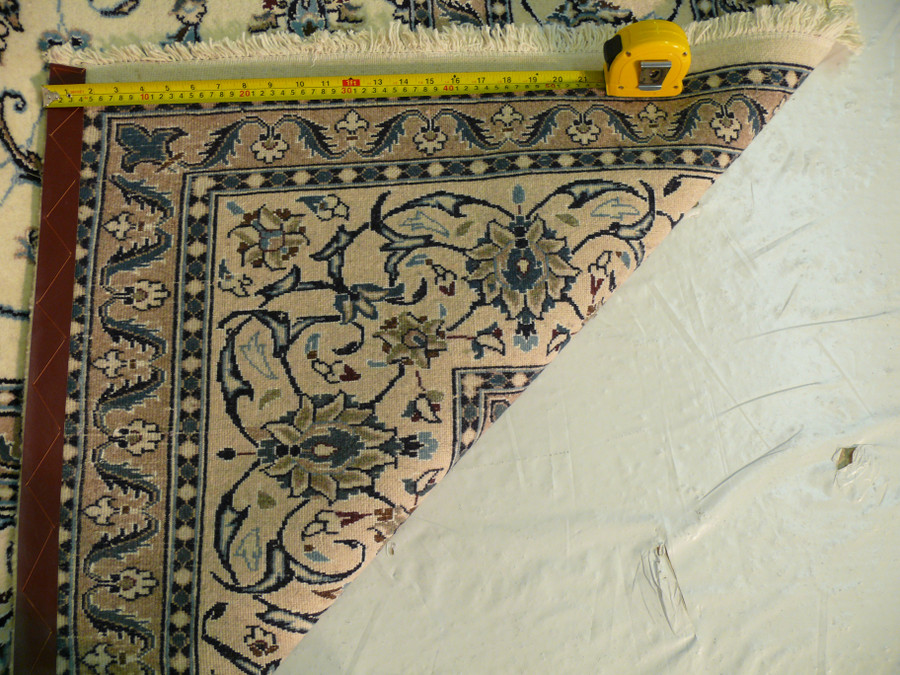 Backside of rug showing weave density and foundation under beige field