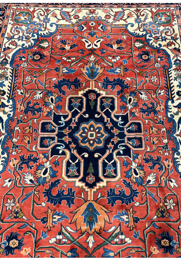 Central medallion detail of a Persian Heriz rug showing navy medallion, angular outlines, and traditional floral geometry