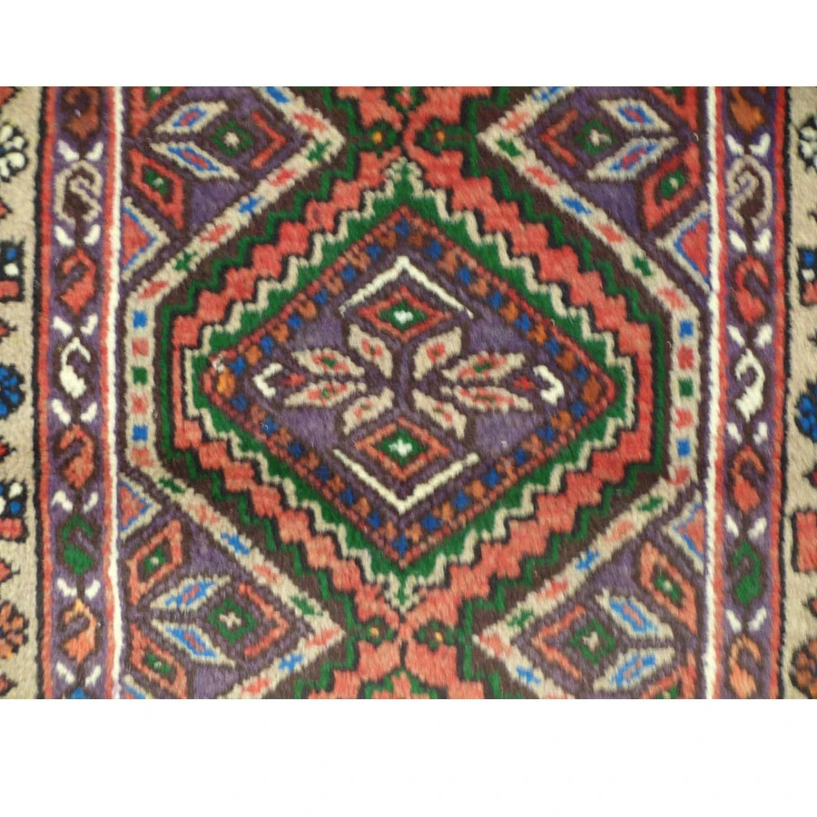 Close-up of the geometric patterns and vibrant colors on the Persian Enjlas rug