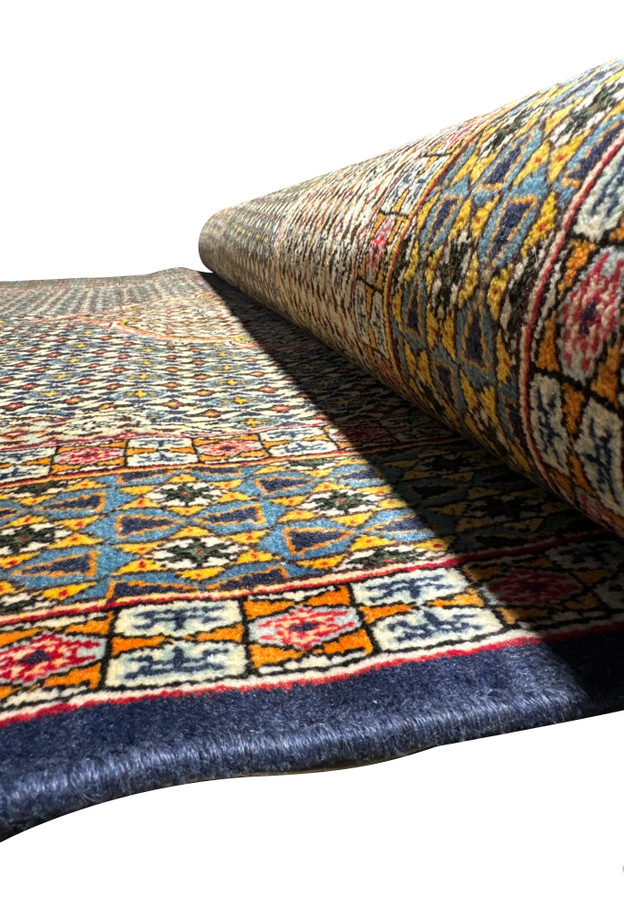 Rolled 4'5 x 7' Persian Qum Rug showing texture of kork and silk fibers