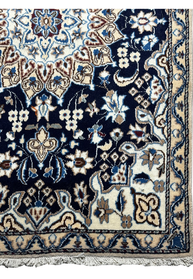 Corner detail of the Persian Nain rug with fringe, showcasing the precision of the guard bands and motifs