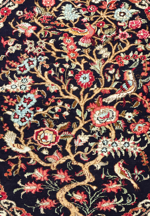 Persian Qum silk rug's artistic floral pattern and the delicate craftsmanship visible on the rug's surface