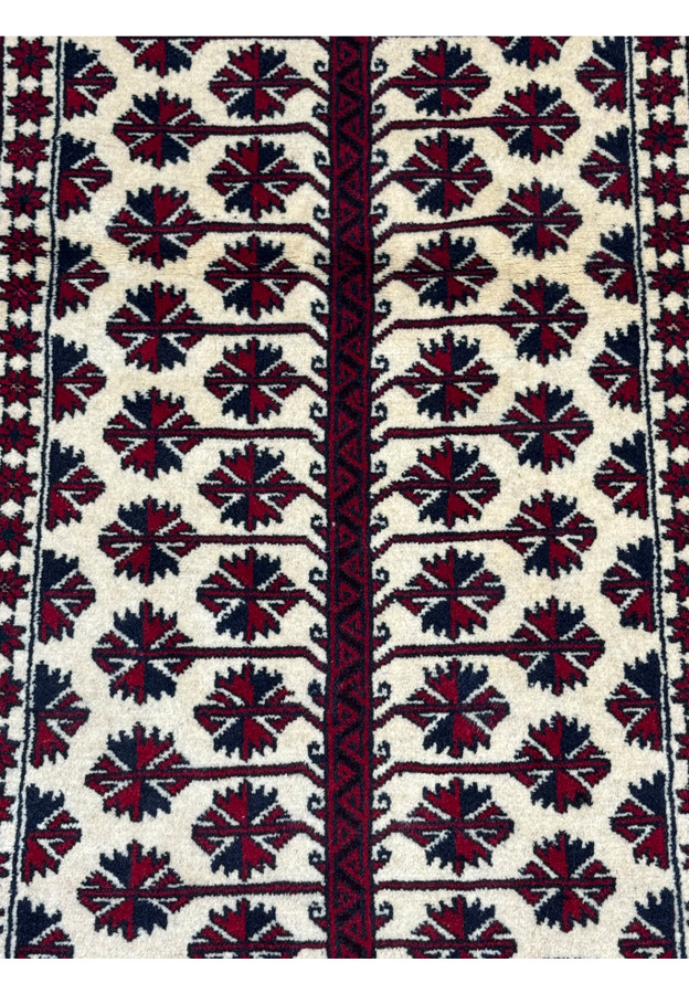 Close-up of the intricate geometric patterns and tribal motifs on the Persian Baluch Prayer Rug