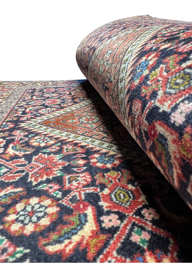 Partial view of the rolled Persian Bijar rug, illustrating the thickness and texture of the weave