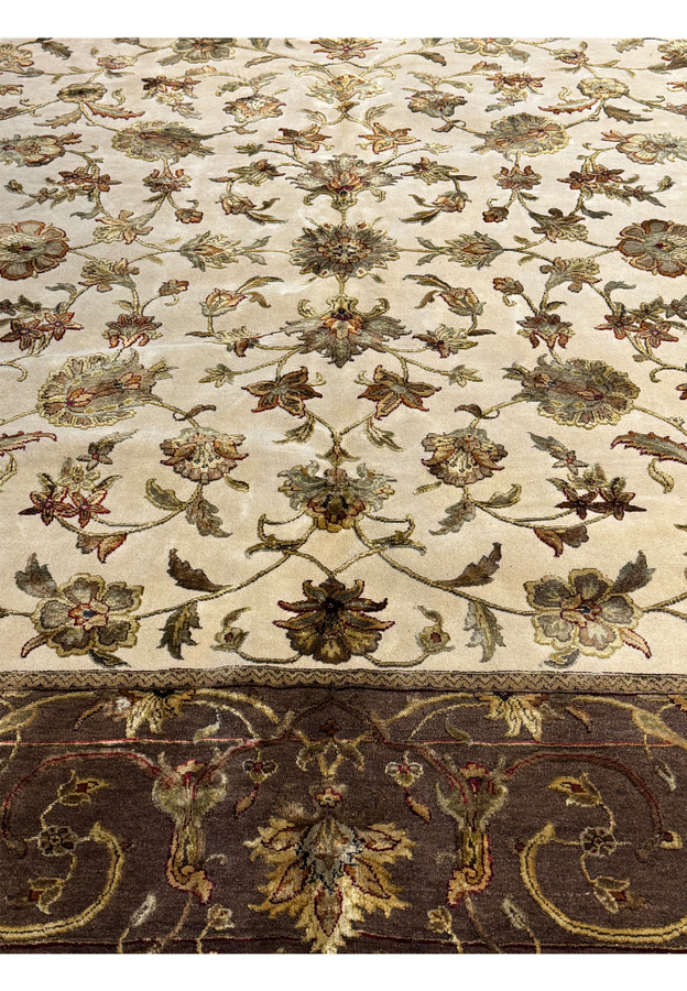 A close-up of the Indian Chobi rug showing the fine detail and color depth in the border and central floral design, with a fringe edge.
